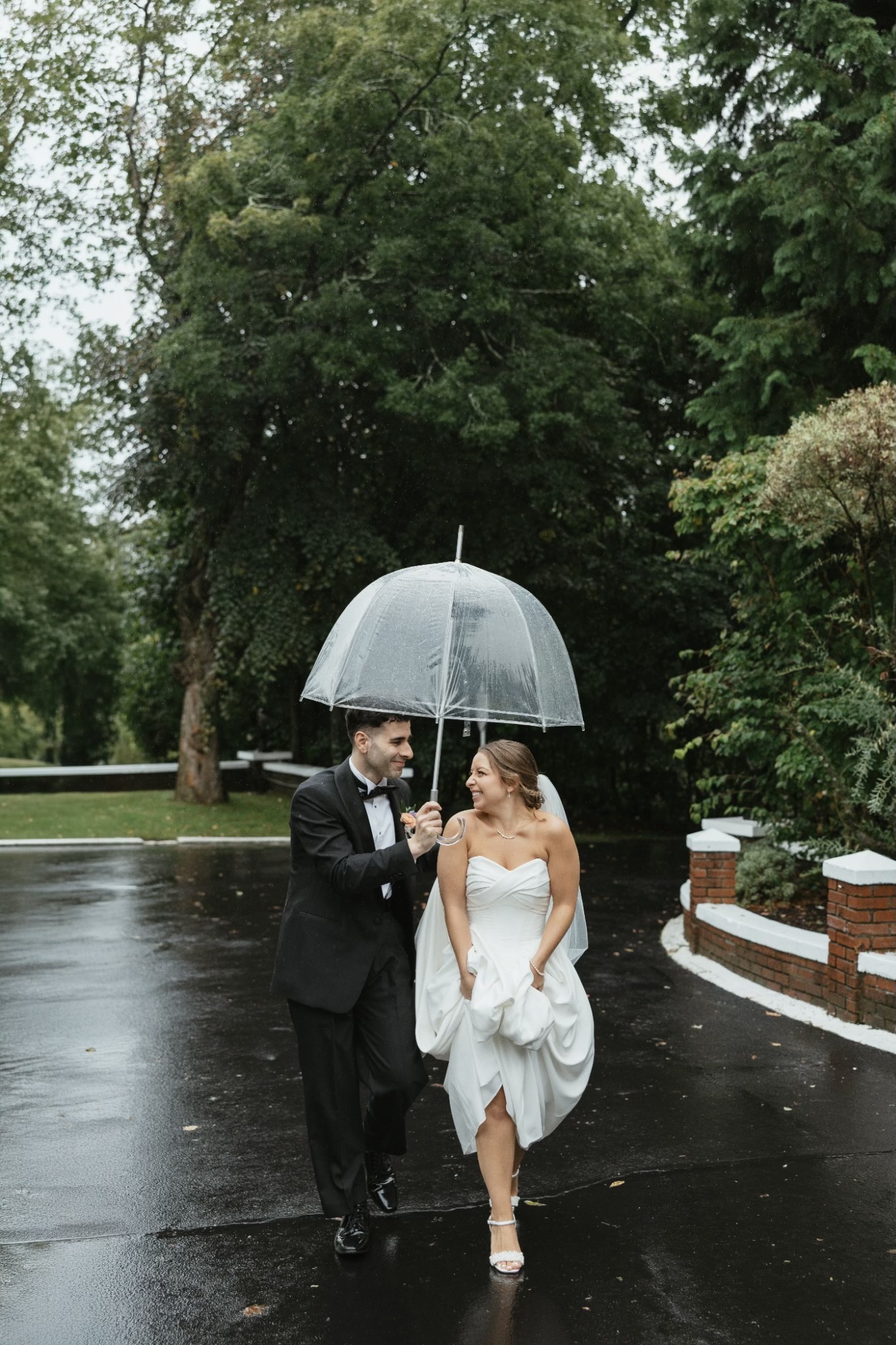 Giovanna and Milad beneath an umbrella on their rainy wedding day